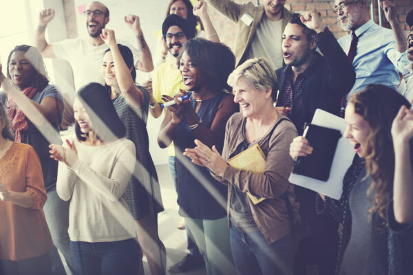 Diverse group celebrating together in a bright room, symbolizing The William Stanley Group’s launch press release covered by Cision PRWeb.